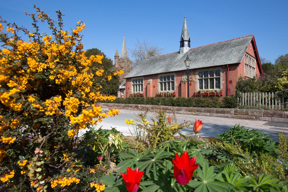 Village of Aldford, England. Picturesque spring view of Aldford Village Hall in Church Lane.