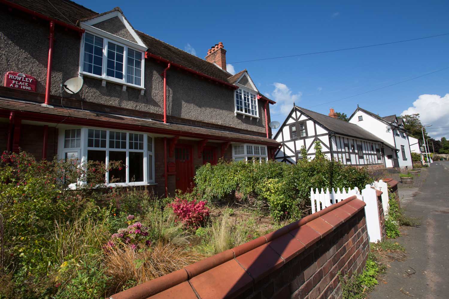 Village of Churton, Cheshire, England. Picturesque view of Victorian terraced houses on Churton’s Chester Road.